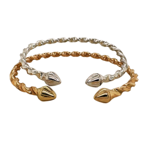 Twisted open cuff bracelet featuring textured gold and silver metal bands with polished conical end caps, shown on a plain white background.