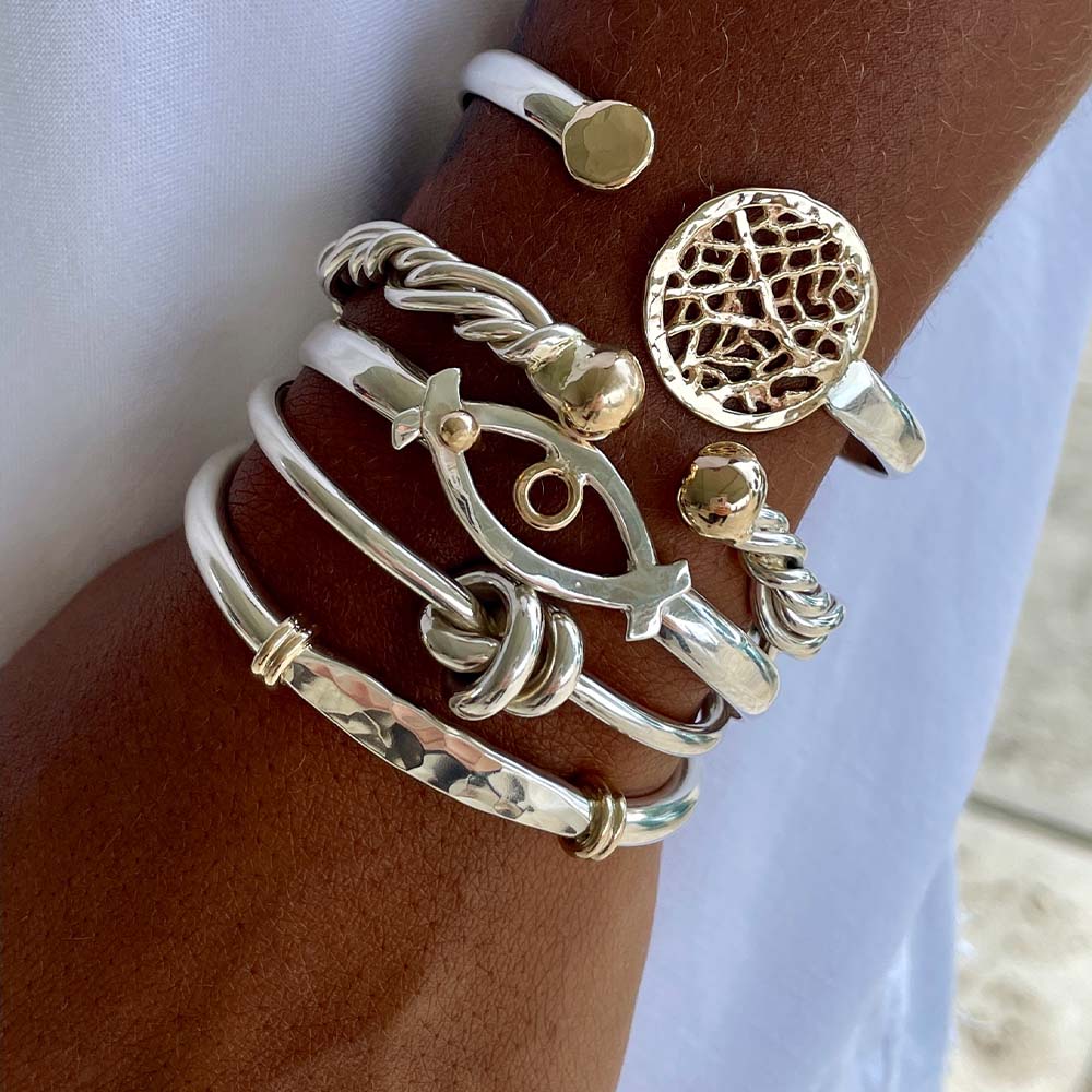 Silver Caribbean design bracelets and bangles on woman's wrist
