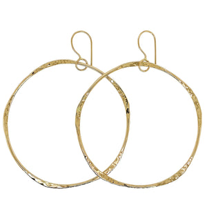 Hammered hoop earrings in gold.